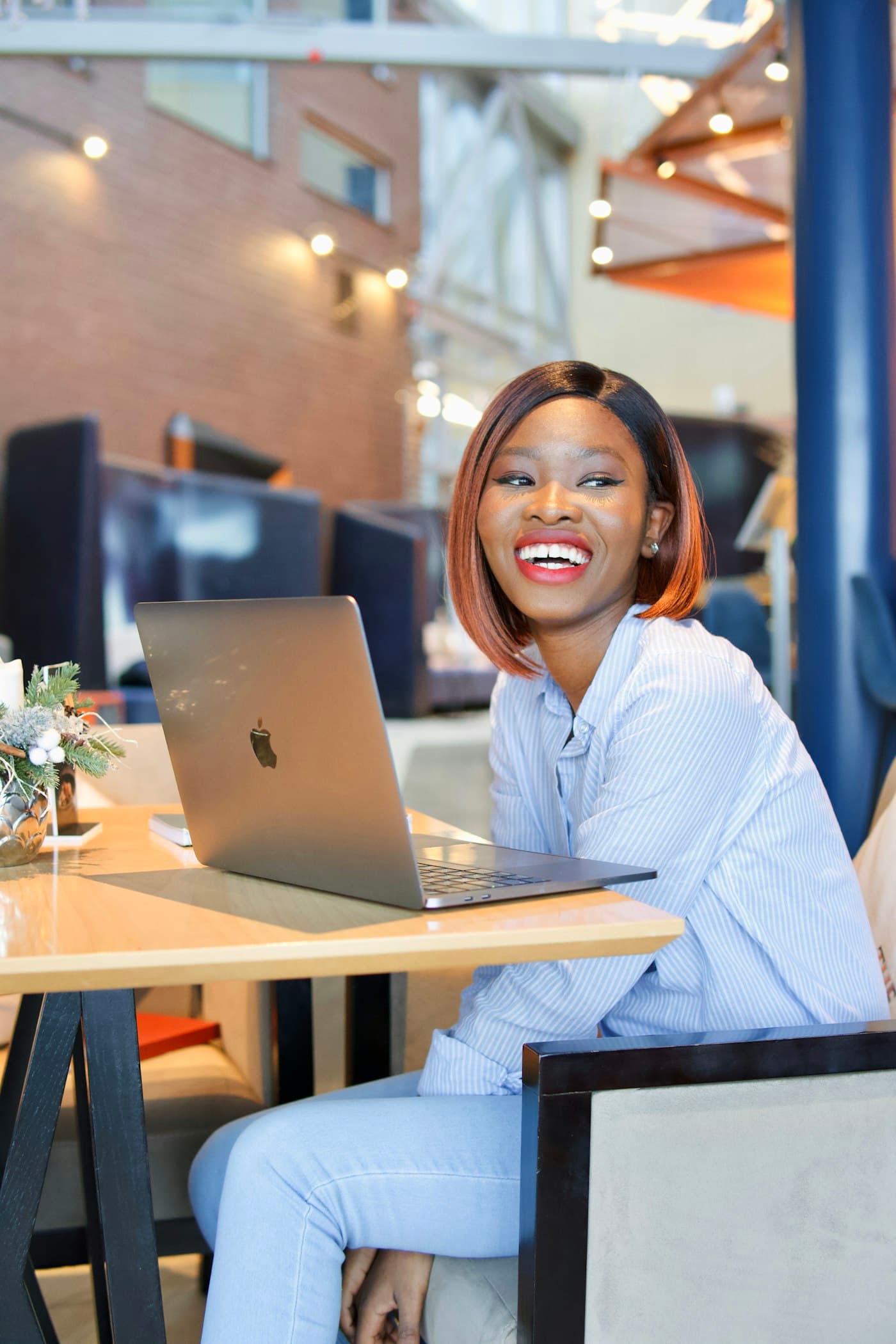 A freelancer smiling at her laptop, the moment a payment lands
